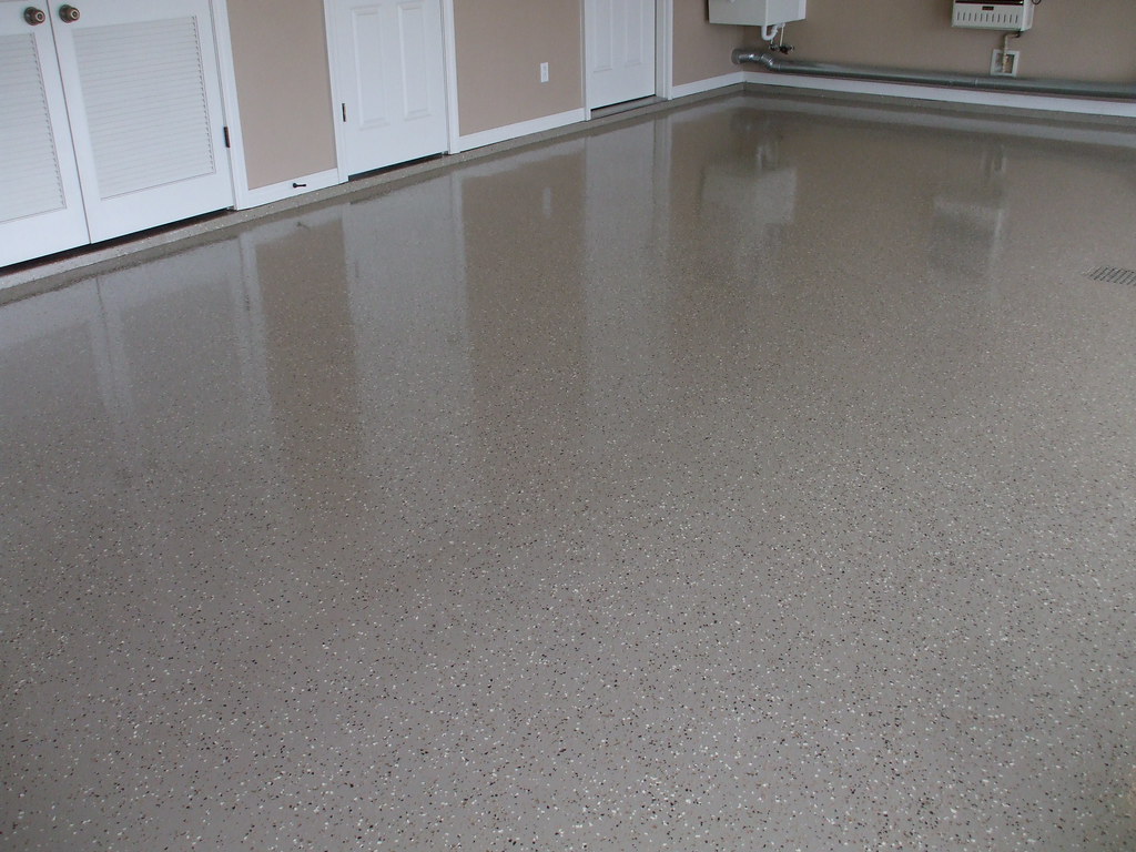 Finished garage floor with a light gray decorative flake coating and a glossy surface
